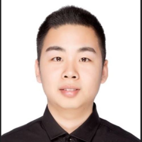 A young man smiles at the camera