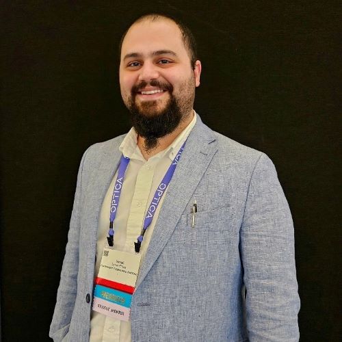 A young man smiles at the camera