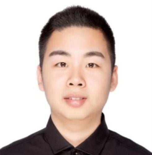 A young man smiles at the camera