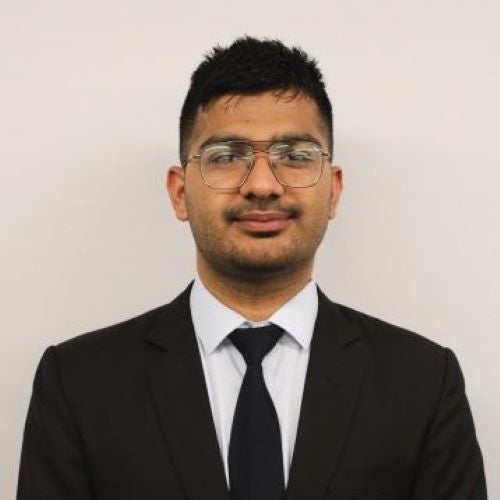 A young man smiles at the camera