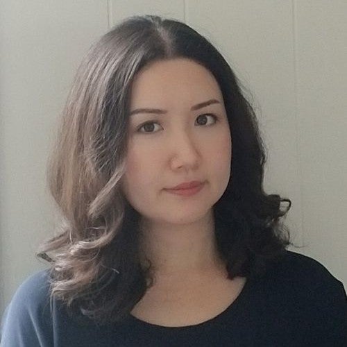 A headshot view of a young woman looking towards the photographer