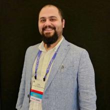 A young man smiles at the camera