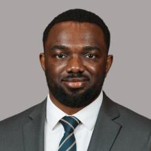 A young man smiles at the camera