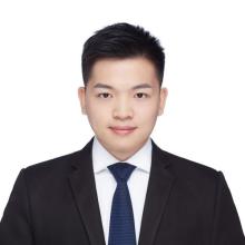 A young man in a suit smiles at the camera