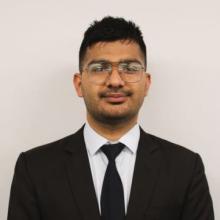 A young man smiles at the camera